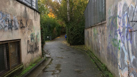 Mit Graffitis besprühter, enger Durchgang