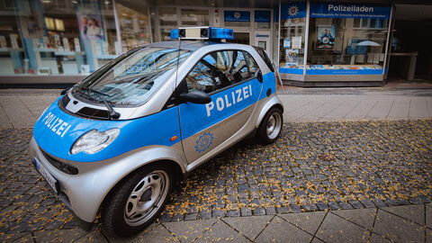 Polizeiliche Beratungsstelle in Kassel ; Ein parkender PKW Smart in Polizeifarben mit Blaulicht vor den Schaufenstern des Polizeiladens in der Kasseler Innenstadt