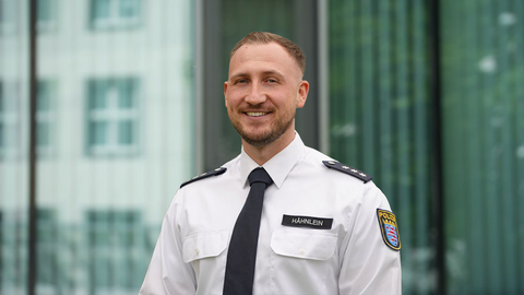 Florian Hähnlein in weißer Uniform vor einem Gebäude