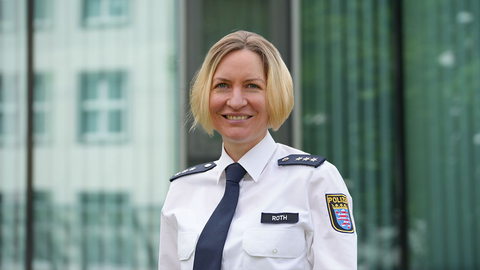 Ilka Roth in weißer Uniform vor einem Gebäude