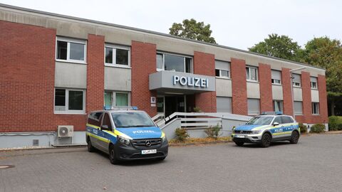 Gebäude des Polizeireviers mit parkenden Polizeiautos davor.