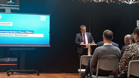 Klaus Wittich, Polizeivizepräsident des Polizeipräsidiums Nordhessen; Herr Wittich steht während seiner Grußworte an einem Rednerpult mit Blickrichtung Publikum, im Hintergrund eine Präsentationswand 