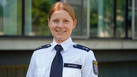Portraitbild von Julia Barzen in Uniform vor einem Gebäude