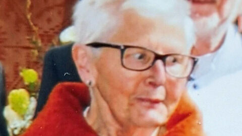 Vermisste 74-jährigen Margarete K. aus Frankenberg (Eder); Foto zeigt die Vermisste mit weißem Haar, einer schwarzen Brille und roter Jacke vor unscharfem Hintergrund