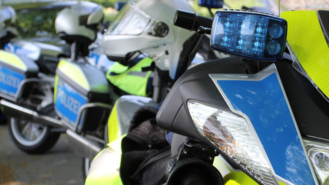 Mehrere Polizeimotorräder stehen nebeneinander auf einem Parkplatz.