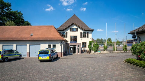 Gebäude der Polizeistation in Stadtallendorf mit einem parkendem Polizeiauto davor.