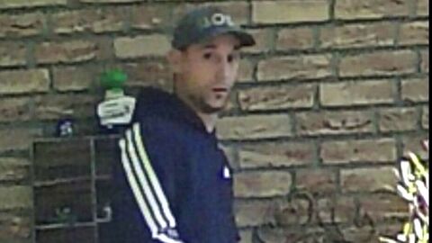 Ein Mann in blauem Trainingsanzug mit weißen Streifen und einer Basecap