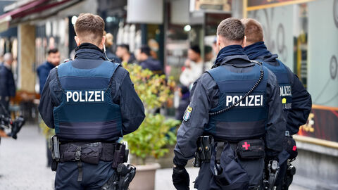 3 Polizeibeamte beim Einsatz, Ansicht von hinten