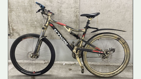 Ein schwarz-rot-goldenes Mountainbike der Marke BTWIN, Modell Rockrider