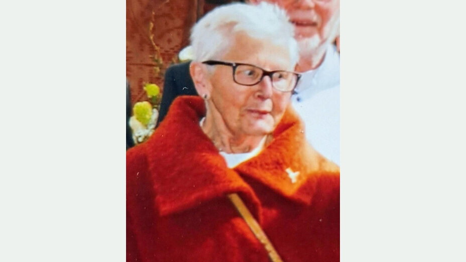 Vermisste 74-jährigen Margarete K. aus Frankenberg (Eder); Foto zeigt die Vermisste mit weißem Haar, einer schwarzen Brille und roter Jacke vor unscharfem Hintergrund