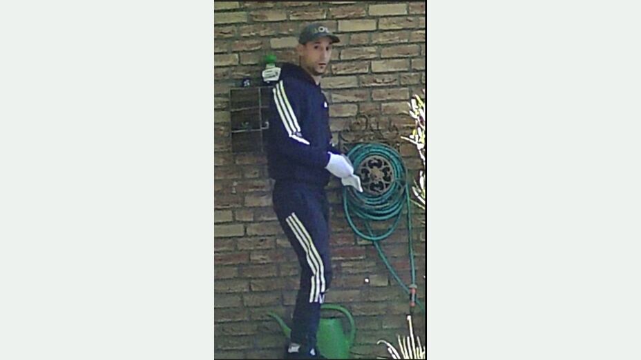 Ein Mann in blauem Trainingsanzug mit weißen Streifen und einer Basecap