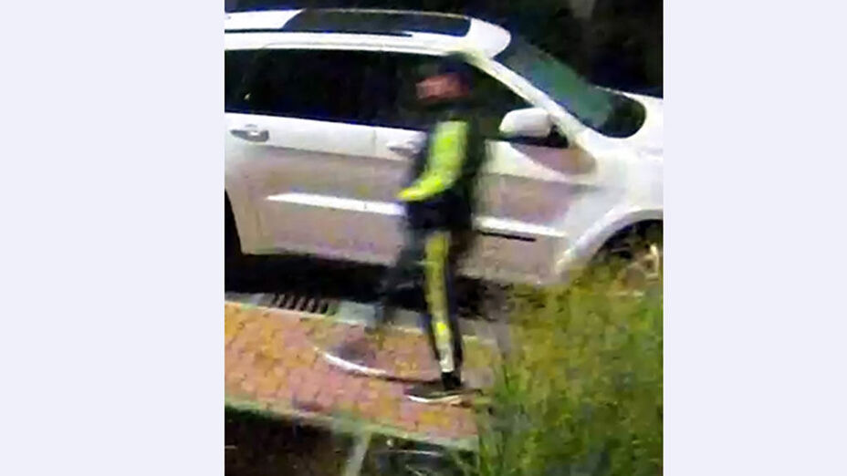 01 Tatverdächtige Person im Trainingsanzug mit neongelben Applikationen auf Gehweg